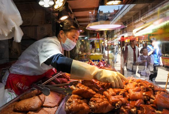 (260127) -- KUNMING, Jan. 27, 2026 (Xinhua) -- A vendor sells marinated meat at Daguan Zhuanxin farmers' market in Kunming, southwest China's Yunnan Province, Jan. 27, 2026. While preserving the original function of a farmers' market, Daguan Zhuanxin farmers' market has now been upgraded to a complex of cultural experience, dining and entertainment, which offers tourists a window to experience local flavor and vibe. (Xinhua/Chen Xinbo)