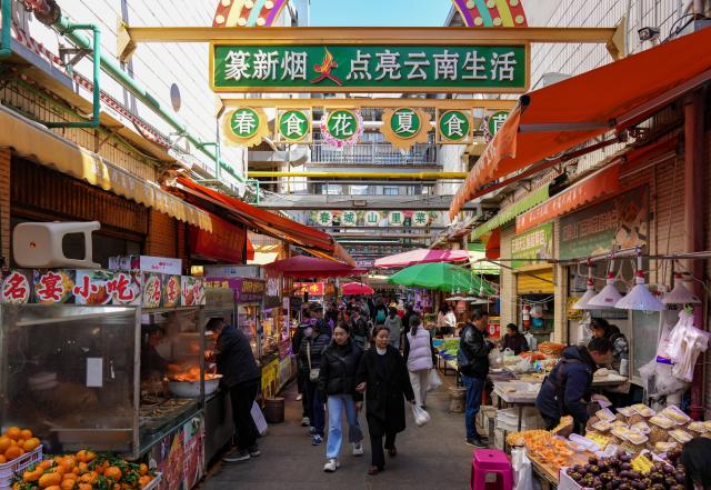 (260127) -- KUNMING, Jan. 27, 2026 (Xinhua) -- People are pictured at Daguan Zhuanxin farmers' market in Kunming, southwest China's Yunnan Province, Jan. 27, 2026. While preserving the original function of a farmers' market, Daguan Zhuanxin farmers' market has now been upgraded to a complex of cultural experience, dining and entertainment, which offers tourists a window to experience local flavor and vibe. (Xinhua/Chen Xinbo)
