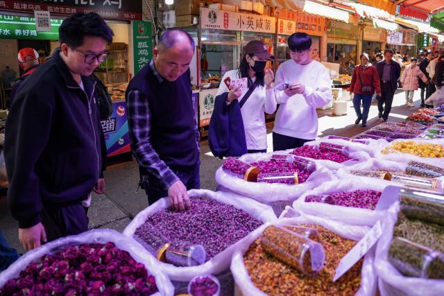 (260127) -- KUNMING, Jan. 27, 2026 (Xinhua) -- People buy rose tea at Daguan Zhuanxin farmers' market in Kunming, southwest China's Yunnan Province, Jan. 27, 2026. While preserving the original function of a farmers' market, Daguan Zhuanxin farmers' market has now been upgraded to a complex of cultural experience, dining and entertainment, which offers tourists a window to experience local flavor and vibe. (Xinhua/Chen Xinbo)