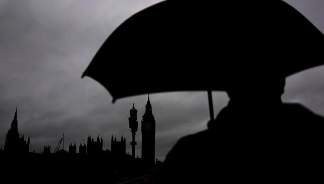 (260127) -- LONDON, Jan. 27, 2026 (Xinhua) -- A man with an umbrella walks near the Big Ben in London, Britain, Jan. 27, 2026, as Storm Chandra brings rain to much of the country. (Xinhua/Li Ying)