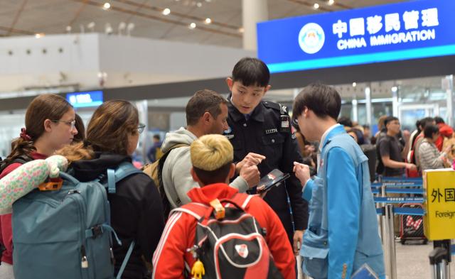 (260128) -- BEIJING, Jan. 28, 2026 (Xinhua) -- A police officer of the Beijing General Station of Exit and Entry Frontier Inspection provides information to foreign tourists at Beijing Capital International Airport in Beijing, capital of China, Jan. 9, 2026.
  Fueled by China's expanding visa-free policies, inbound travel surged in 2025, with visa-free entries jumping 49.5 percent year-on-year to nearly 30.1 million, official data showed.
  The National Immigration Administration said on Wednesday that international visitors made over 82 million crossings in total, marking a 26.4 percent year-on-year increase.
  Currently, China offers visa-free entry to citizens of 76 countries. Plus, travelers from 55 countries can take advantage of a 240-hour visa-free transit policy at 65 different entry points. 
  Beyond short-term visits, this openness is fostering a vibrant community of international residents. More scholars, students, and professionals are choosing to live and work in China, deepening people-to-people bonds. China, with much to be explored and a lot more to offer, continues to captivate hearts and minds worldwide. (Photo by Zu Guobao/Xinhua)