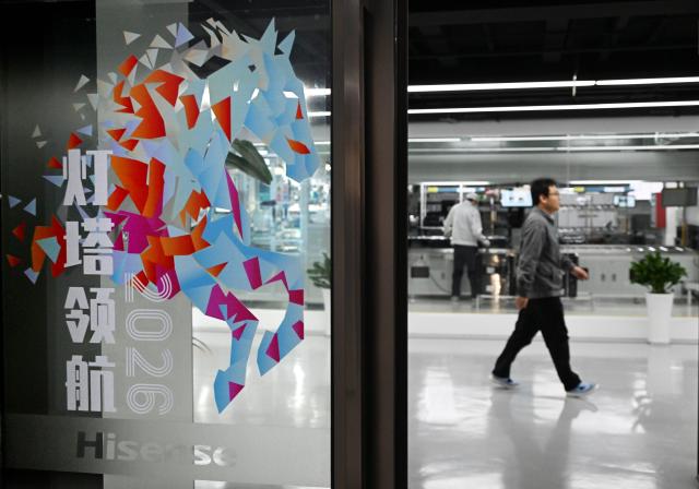 (260128) -- BEIJING, Jan. 28, 2026 (Xinhua) -- A staff member of Hisense Visual Technology walks past a production line in Qingdao, east China's Shandong Province, Jan. 13, 2026. (Xinhua/Li Ziheng)