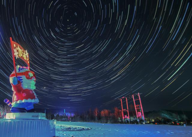 (260128) -- HARBIN, Jan. 28, 2026 (Xinhua) -- This stack composite photo taken on Jan. 18, 2026 shows a view of the starry sky at Yabuli Ski Resort in northeast China's Heilongjiang Province. China's northernmost Heilongjiang Province has entered the golden period for winter starry sky observation. With auroras occasionally making an appearance, the brilliant starry sky and the icy landscape together unfold a serene and breathtaking picture. (Photo by Zeng Dong/Xinhua)