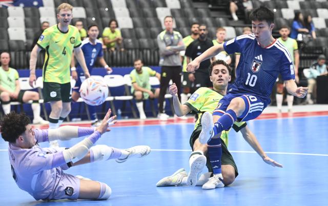 (260128) -- JAKARTA, Jan. 28, 2026 (Xinhua) -- Uchida Shunta (R) of Japan shoots during the group C match between Japan and Australia at the AFC Futsal Asian Cup 2026 in Jakarta, Indonesia, Jan. 28, 2026. (Xinhua/Zulkarnain)