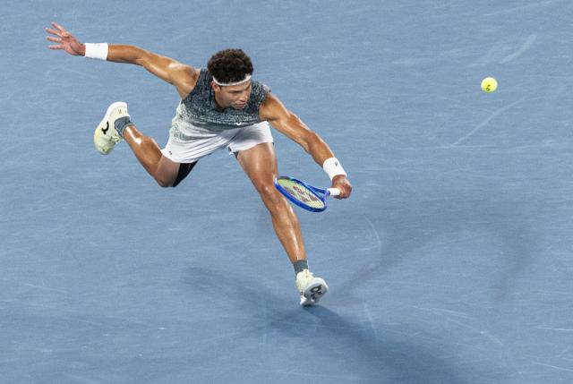 (260128) -- MELBOURNE, Jan. 28, 2026 (Xinhua) -- Ben Shelton hits a return during the men's singles quarterfinal match between Ben Shelton of the United States and Jannik Sinner of Italy at the Australian Open tennis tournament in Melbourne, Australia, Jan. 28, 2026. (Photo by Hu Jingchen/Xinhua)