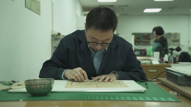 (260128) -- TIANJIN, Jan. 28, 2026 (Xinhua) -- Wang Hongjie works in a restoration room at Tianjin Library in northern China's Tianjin, on Dec. 10, 2025. TO GO WITH "Across China: Between paper and pixels, a library repairs what time wears down" (Xinhua/Bao Qingling)