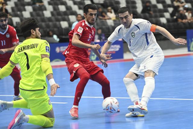 (260128) -- JAKARTA, Jan. 28, 2026 (Xinhua) -- Ilkhomjon Khamroev (R) of Uzbekistan shoots during the group C match between Uzbekistan and Tajikistan at the AFC Futsal Asian Cup 2026 in Jakarta, Indonesia, Jan. 28, 2026. (Xinhua/Zulkarnain)