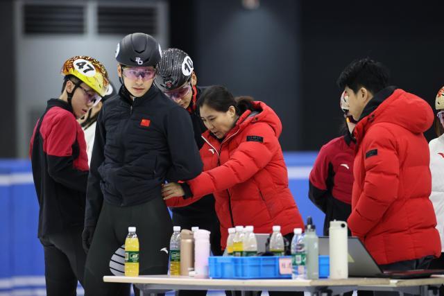 (260129) -- BEIJING, Jan. 29, 2026 (Xinhua) -- Zhang Jing (C), head coach of China's short track speed skating team, adjusts Liu Shaoang's suit during a training session ahead of the upcoming Milan-Cortina 2026 Winter Olympics in Beijing, China, Jan. 29, 2026. (Xinhua/Zhang Chen)