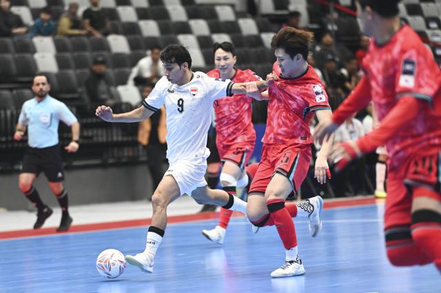 (260129) -- JAKARTA, Jan. 29, 2026 (Xinhua) -- Eom Jiyong (2nd R) of South Korea vies with Salim Kadhim Al-Darraji (L) of Iraq during the group A match between South Korea and Iraq at the AFC Futsal Asian Cup 2026 in Jakarta, Indonesia, Jan. 29, 2026. (Xinhua/Zulkarnain)