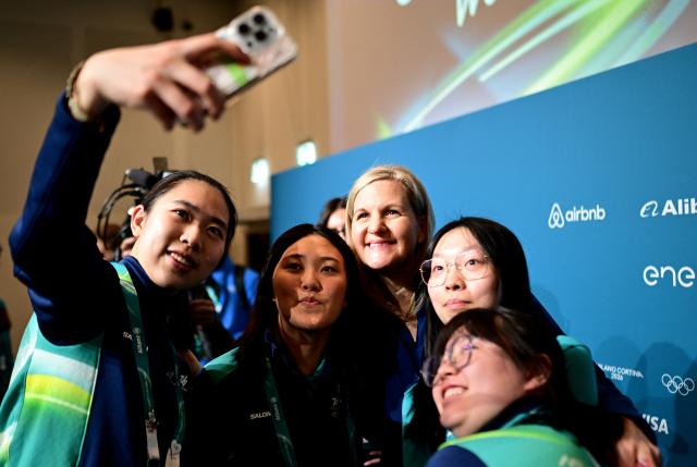 (260129) -- MILAN, Jan. 29, 2026 (Xinhua) -- IOC President Kirsty Coventry (C) takes selfies with volunteers after a meeting with Milano Cortina 2026 volunteers in Milan, Italy, Jan. 29, 2026. (Photo by Daniele Mascolo/Pool Photo via Reuters)