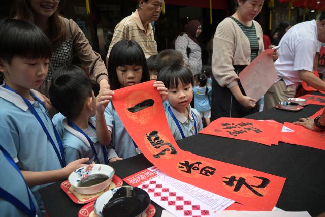 (260130) -- SINGAPORE, Jan. 30, 2026 (Xinhua) -- Children queue to receive gift calligraphy works as part of the celebrations for the upcoming Spring Festival, at Singapore's financial center on Jan. 29, 2026. (Photo by Then Chih Wey/Xinhua)