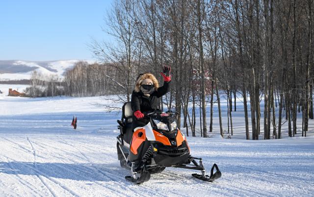 (260130) -- YAKESHI, Jan. 30, 2026 (Xinhua) -- A tourist rides snow motorbike at the Phoenix Mountain scenic area in Yakeshi of Hulun Buir, north China's Inner Mongolia Autonomous Region, Jan. 21, 2026. Yakeshi has been an important base for cold-area automotive testing due to its long and freezing winter season. A large number of engineers and technicians pay regular visit for business purpose to the city during the winter, but they also become a stable client group for other services available here. 
   In the mean time, local authorities are further improving their infrastructure and services to attract more plain tourists for the colorful winter-time amusements available in the city. (Xinhua/Bei He)