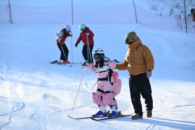 (260130) -- YAKESHI, Jan. 30, 2026 (Xinhua) -- Tourists ski at the Phoenix Mountain scenic area in Yakeshi of Hulun Buir, north China's Inner Mongolia Autonomous Region, Jan. 21, 2026. Yakeshi has been an important base for cold-area automotive testing due to its long and freezing winter season. A large number of engineers and technicians pay regular visit for business purpose to the city during the winter, but they also become a stable client group for other services available here. 
   In the mean time, local authorities are further improving their infrastructure and services to attract more plain tourists for the colorful winter-time amusements available in the city. (Xinhua/Bei He)