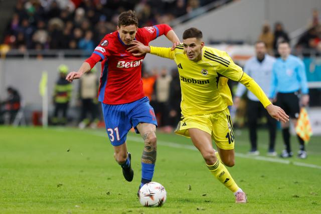 (260130) -- BUCHAREST, Jan. 30, 2026 (Xinhua) -- FCSB's Juri Cisotti (L) vies with Fenerbahce's Mert Muldur during the UEFA Europa League football match between Fenerbahce and FCSB at Arena Nationala stadium in Bucharest, Romania, Jan. 29, 2026. (Photo by Cristian Cristel/Xinhua)