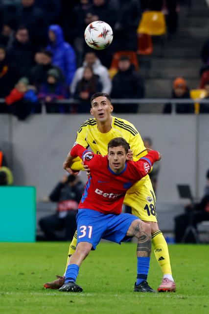 (260130) -- BUCHAREST, Jan. 30, 2026 (Xinhua) -- FCSB's Juri Cisotti (bottom) vies with Fenerbahce's Mert Muldur (top) during the UEFA Europa League football match between Fenerbahce and FCSB at Arena Nationala stadium in Bucharest, Romania, Jan. 29, 2026. (Photo by Cristian Cristel/Xinhua)