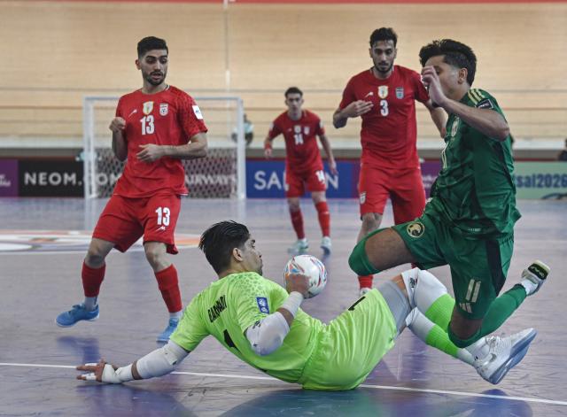 (260130) -- JAKARTA, Jan. 30, 2026 (Xinhua) -- Bagher Mohammadi (bottom), goalkeeper of Iran, vies with Abdullah Mohammed Alaoeei of Saudi Arabia during the Group D match between Saudi Arabia and Iran at the AFC Futsal Asian Cup 2026 in Jakarta, Indonesia, Jan. 30, 2026. (Xinhua/Agung Kuncahya B.)
