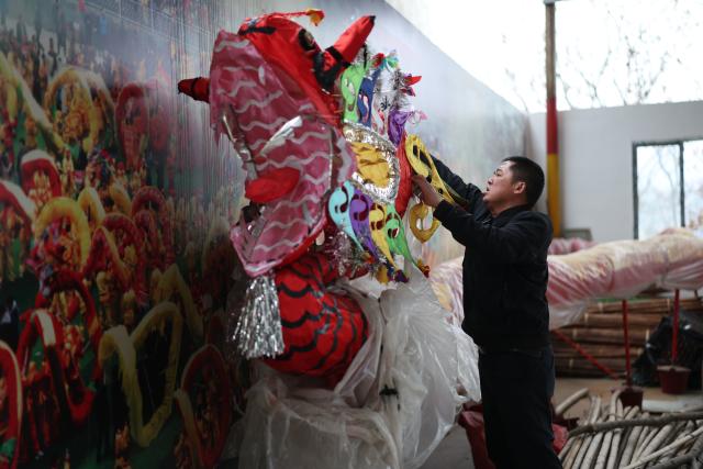 (260130) -- SHIQIAN, Jan. 30, 2026 (Xinhua) -- Dai Xin checks a finished Maolong (hairy dragon) latern at his residence in Shiqian County, southwest China's Guizhou Province, Jan. 27, 2026. The "Maolong (hairy dragon) Festival" of Gelao ethnic group is a national-level intangible cultural heritage. Maolong laterns, the theme artifacts of the Maolong Festival, is a school of dragon lanterns unique to Shiqian. 
   A Malong lantern contains a bamboo strip framework, wrapped in skillfully cut colorful paper strips that give it a "hairy" appearance.
   Dai Xin is the national-level inheritor of this craft. His father Dai Shangfu is also a renowned craftsman specialized in Maolong making and Maolong dance. 
   The Dai family, in which the Maolong craft has been passed down for six generations, is among the many guardians of legacies of the Gelao ethnic group. (Xinhua/Liu Xu)