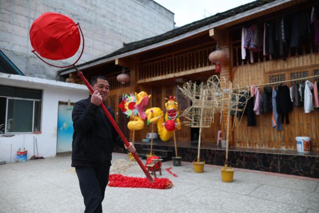 (260130) -- SHIQIAN, Jan. 30, 2026 (Xinhua) -- Dai Xin practices dragon dance at his residence in Shiqian County, southwest China's Guizhou Province, Jan. 27, 2026. The "Maolong (hairy dragon) Festival" of Gelao ethnic group is a national-level intangible cultural heritage. Maolong laterns, the theme artifacts of the Maolong Festival, is a school of dragon lanterns unique to Shiqian. 
   A Malong lantern contains a bamboo strip framework, wrapped in skillfully cut colorful paper strips that give it a "hairy" appearance.
   Dai Xin is the national-level inheritor of this craft. His father Dai Shangfu is also a renowned craftsman specialized in Maolong making and Maolong dance. 
   The Dai family, in which the Maolong craft has been passed down for six generations, is among the many guardians of legacies of the Gelao ethnic group. (Xinhua/Liu Xu)