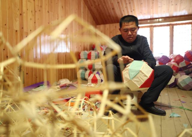 (260130) -- SHIQIAN, Jan. 30, 2026 (Xinhua) -- Dai Xin makes components of Maolong (hairy dragon) latern at his residence in Shiqian County, southwest China's Guizhou Province, Jan. 27, 2026. The "Maolong (hairy dragon) Festival" of Gelao ethnic group is a national-level intangible cultural heritage. Maolong laterns, the theme artifacts of the Maolong Festival, is a school of dragon lanterns unique to Shiqian. 
   A Malong lantern contains a bamboo strip framework, wrapped in skillfully cut colorful paper strips that give it a "hairy" appearance.
   Dai Xin is the national-level inheritor of this craft. His father Dai Shangfu is also a renowned craftsman specialized in Maolong making and Maolong dance. 
   The Dai family, in which the Maolong craft has been passed down for six generations, is among the many guardians of legacies of the Gelao ethnic group. (Xinhua/Liu Xu)