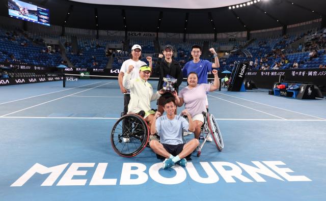 (260130) -- MELBOURNE, Jan. 30, 2026 (Xinhua) -- Wang Ziying (R, 2nd row)/Li Xiaohui (L, 2nd row) pose with their team members after the women's wheelchair doubles final between Wang Ziying/Li Xiaohui (China) and Zhu Zhenzhen (China)/Kamiji Yui (Japan) at the Australian Open tennis tournament in Melbourne, Australia, Jan. 30, 2026. (Xinhua/Ma Ping)