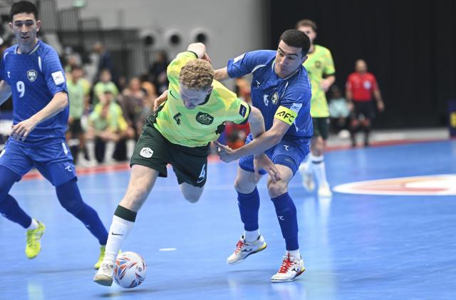 (260130) -- JAKARTA, Jan. 30, 2026 (Xinhua) -- Dominic Cox (C) of Australia vies with Ilkhomjon Khamroev of Uzbekistan during the group C match between Australia and Uzbekistan at the AFC Futsal Asian Cup 2026 in Jakarta, Indonesia, Jan. 30, 2026. (Xinhua/Zulkarnain)
