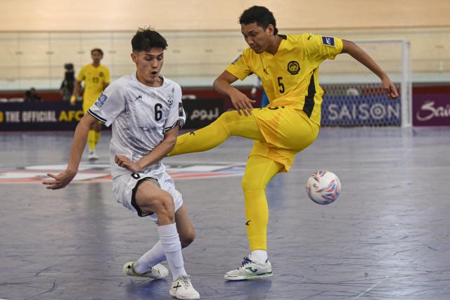 (260130) -- JAKARTA, Jan. 30, 2026 (Xinhua) -- Mohamad Awalluddin Nawi (R) of Malaysia vies with Khodadad Ebrahimi of Afghanistan during the match in Group D between Malaysia and Afghanistan at the AFC Futsal Asian Cup 2026 in Jakarta, Indonesia, Jan. 30, 2026. (Xinhua/Agung Kuncahya B.)