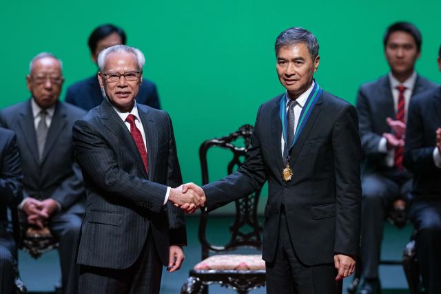 (260130) -- MACAO, Jan. 30, 2026 (Xinhua) -- Sam Hou Fai (L), chief executive of the Macao Special Administrative Region (SAR), presents the Golden Lotus Decoration to Ho Veng On during an award ceremony in Macao, south China, Jan. 30, 2026. The award ceremony was held by China's Macao SAR to confer honors on individuals and entities for their achievements, contributions, and services to the SAR in 2025. (Xinhua/Cheong Kam Ka)