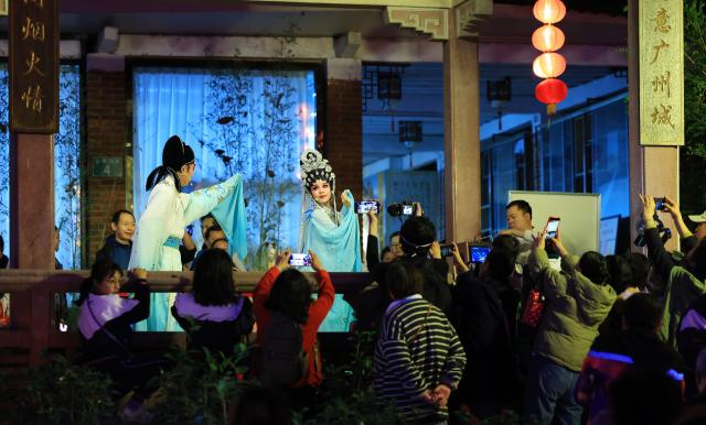 (260130) -- GUANGZHOU, Jan. 30, 2026 (Xinhua) -- People watch a Cantonese opera performance during the 2026 Guangzhou Spring Festival lantern show in Guangzhou, south China's Guangdong Province, Jan. 30, 2026. The event kicked off at the Yuexiu Park in Guangzhou on Friday, featuring 85 groups of distinctive lantern displays scattered throughout the ten major tourist areas of the entire park, and will last until March, 8. (Xinhua/Wang Ruiping)