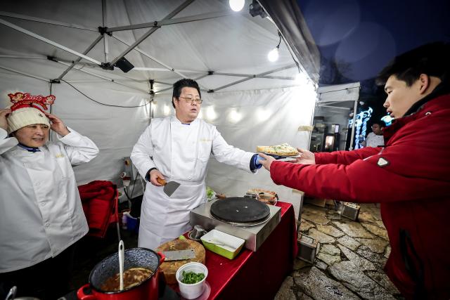 (260130) -- BUDAPEST, Jan. 30, 2026 (Xinhua) -- A visitor buys Chinese food at "A Taste of China, Chinese Food Nights" event held at Budapest Zoo and Botanical Garden in Budapest, Hungary, Jan. 30, 2026. The Budapest Zoo and Botanical Garden was filled with the aromas of Chinese food and snacks on Friday evening as an event themed "A Taste of China, Chinese Food Nights" got underway. (Photo by David Balogh/Xinhua)