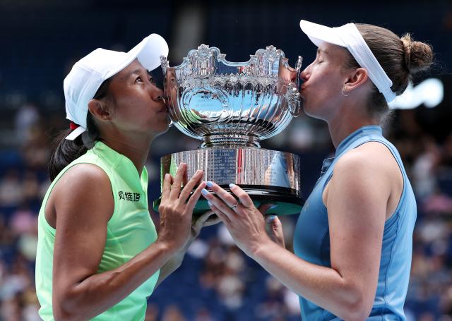 (260131) -- MELBOURNE, Jan. 31, 2026 (Xinhua) -- Zhang Shuai (L)/Elise Mertens kiss the trophy during the awarding ceremony for the women's doubles final match between Zhang Shuai (China)/Elise Mertens (Belgium) and Anna Danilina (Kazakhstan)/Aleksandra Krunic (Serbia) at the Australian Open tennis tournament in Melbourne, Australia, Jan. 31, 2026. (Xinhua/Ma Ping)