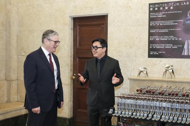 (260131) -- SHANGHAI, Jan. 31, 2026 (Xinhua) -- Lou Yongqi, president of Shanghai University of Engineering Science, introduces for British Prime Minister Keir Starmer during Starmer's visit at the Design Innovation Institute Shanghai in east China's Shanghai, Jan. 31, 2026. (Xinhua/Wang Xiang)