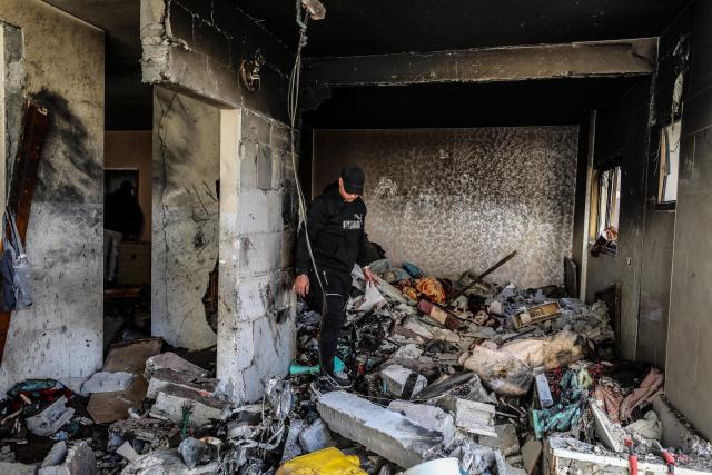 (260131) -- GAZA, Jan. 31, 2026 (Xinhua) -- A Palestinian checks a damaged building following Israeli airstrikes in Gaza City, on Jan. 31, 2026. At least 12 people were killed in Israeli airstrikes on Gaza on Saturday, multiple sources reported, citing hospital officials in the enclave. (Photo by Rizek Abdeljawad/Xinhua)