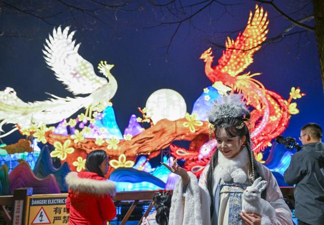 (260201) -- BEIJING, Feb. 1, 2026 (Xinhua) -- A staff member in traditional costumes interacts with the visitors at a lantern festival at the Garden Expo Park in southwest China's Chongqing Municipality, Jan. 30, 2026. (Xinhua/Chen Cheng)