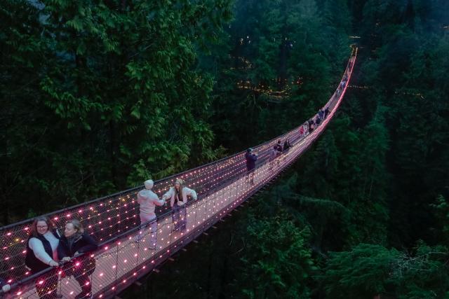 (260201) -- NORTH VANCOUVER, Feb. 1, 2026 (Xinhua) -- People walk across an illuminated suspension bridge during the "Love Lights" event at Capilano Suspension Bridge Park in North Vancouver, British Columbia, Canada, on Jan. 31, 2026. "Love Lights" is a Valentine's Day-themed attraction featuring romantic illuminations and decorations throughout the park. The event kicked off on Jan. 30 and will last until Feb. 22. (Photo by Liang Sen/Xinhua)