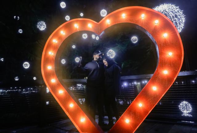 (260201) -- NORTH VANCOUVER, Feb. 1, 2026 (Xinhua) -- A couple take photos with Valentine's Day-themed decorations during the "Love Lights" event at Capilano Suspension Bridge Park in North Vancouver, British Columbia, Canada, on Jan. 31, 2026. "Love Lights" is a Valentine's Day-themed attraction featuring romantic illuminations and decorations throughout the park. The event kicked off on Jan. 30 and will last until Feb. 22. (Photo by Liang Sen/Xinhua)