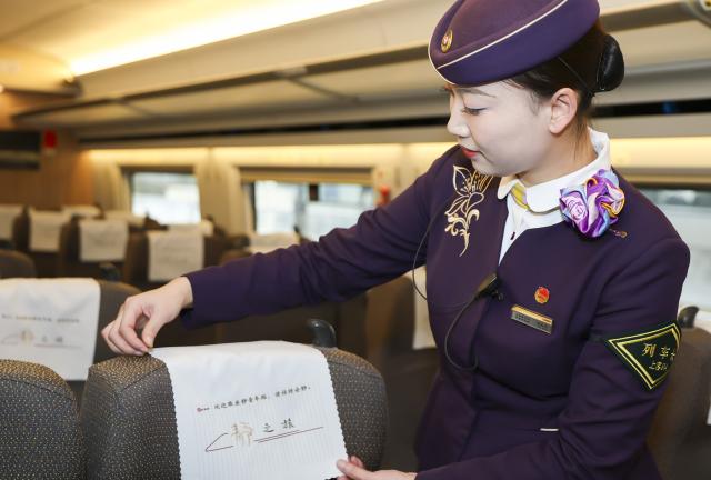 (260201) -- SHANGHAI, Feb. 1, 2026 (Xinhua) -- The conductor of train No. G12 travelling from east China's Shanghai to Beijing, capital of China arranges a headrest cover with a "Keep Quiet" sign at a quiet car on Feb. 1, 2026. More than 8,000 high-speed trains across China will provide quiet car services starting from Feb. 1, 2026. (Xinhua/Wang Xiang)