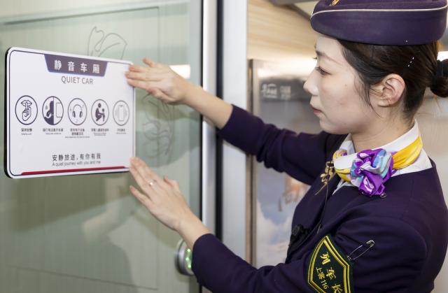 (260201) -- SHANGHAI, Feb. 1, 2026 (Xinhua) -- The conductor of train No. G1373 travelling from east China's Shanghai to Kunming, southwest China's Yunnan Province posts a "Quiet Car" sign at a quiet car on Feb. 1, 2026. More than 8,000 high-speed trains across China will provide quiet car services starting from Feb. 1, 2026. (Xinhua/Wang Xiang)