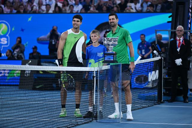 (260201) -- MELBOURNE, Feb. 1, 2026 (Xinhua) -- Carlos Alcaraz (L) and Novak Djokovic (R) take photos with a ballboy before their men's singles final at the Australian Open tennis tournament in Melbourne, Australia, Feb. 1, 2026. (Photo by Wang Shen/Xinhua)