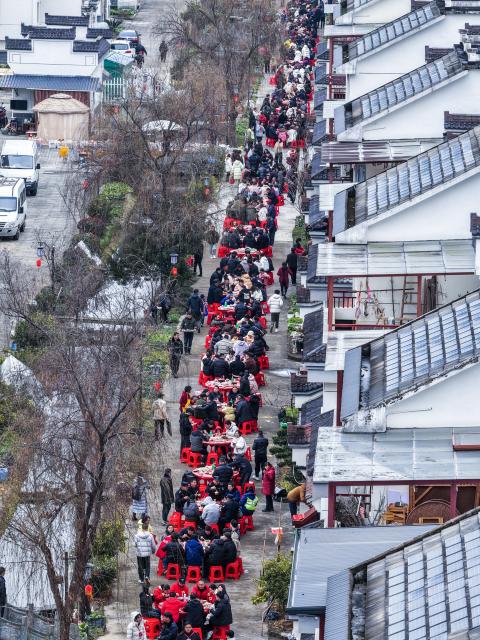 (260201) -- JIANDE, Feb. 1, 2026 (Xinhua) -- An aerial drone photo taken on Feb. 1, 2026 shows people dining on the street in Lianhua Township, east China's Zhejiang Province. A Spring Festival cultural event was held here with great enthusiasm on Sunday. Local residents and tourists enjoyed the festive market, viewed the local art exhibition, participated in traditional games, and savored local foods. (Xinhua/Xu Yu)