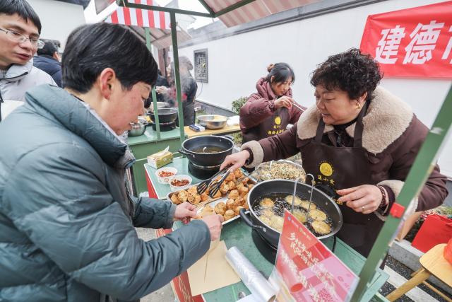 (260201) -- JIANDE, Feb. 1, 2026 (Xinhua) -- People buy local foods at a festive market in Lianhua Township, east China's Zhejiang Province, Feb. 1, 2026. A Spring Festival cultural event was held here with great enthusiasm on Sunday. Local residents and tourists enjoyed the festive market, viewed the local art exhibition, participated in traditional games, and savored local foods. (Xinhua/Xu Yu)