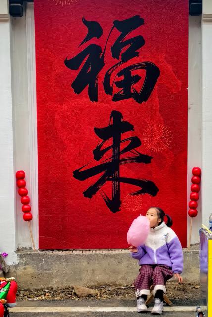 (260201) -- JIANDE, Feb. 1, 2026 (Xinhua) -- A child eats cotton candy at a festive market in Lianhua Township, east China's Zhejiang Province, Feb. 1, 2026. A Spring Festival cultural event was held here with great enthusiasm on Sunday. Local residents and tourists enjoyed the festive market, viewed the local art exhibition, participated in traditional games, and savored local foods. (Xinhua/Xu Yu)