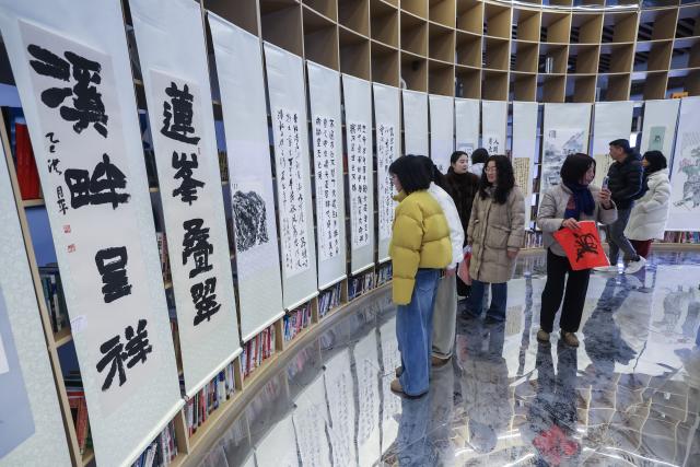 (260201) -- JIANDE, Feb. 1, 2026 (Xinhua) -- People visit an art exhibition in Lianhua Township, east China's Zhejiang Province, Feb. 1, 2026. A Spring Festival cultural event was held here with great enthusiasm on Sunday. Local residents and tourists enjoyed the festive market, viewed the local art exhibition, participated in traditional games, and savored local foods. (Xinhua/Xu Yu)