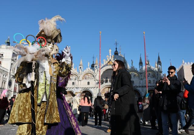 (260202) -- VENICE, Feb. 2, 2026 (Xinhua) -- A reveler dressed up in theme of the Olympic Games poses during Venice Carnival at St. Mark's Square in Venice, Italy, Feb. 1, 2026. The 2026 version of the traditional Venice Carnival runs from Jan. 31 to Feb. 17. (Xinhua/Li Jing)
