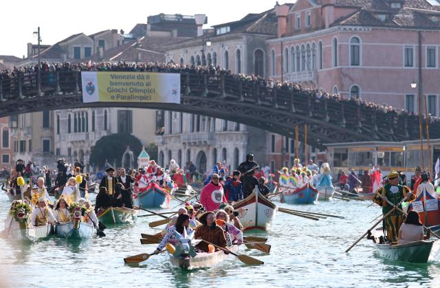 (260202) -- VENICE, Feb. 2, 2026 (Xinhua) -- A banner written "Venice welcome Olympic and Paralympic Games" is seen on the Ponte dell' Accademia during the water parade of Venice Carnival in Venice, Italy, Feb. 1, 2026. The 2026 version of the traditional Venice Carnival runs from Jan. 31 to Feb. 17. (Xinhua/Li Jing)