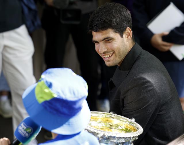 (260202) -- MELBOURNE, Feb. 2, 2026 (Xinhua) -- Carlos Alcaraz of Spain communicates with a ballkid during the 2026 Australian Open men's champion media opportunity at the Royal Exhibition Building in Melbourne, Australia, Feb. 2, 2026. (Xinhua/Ma Ping)