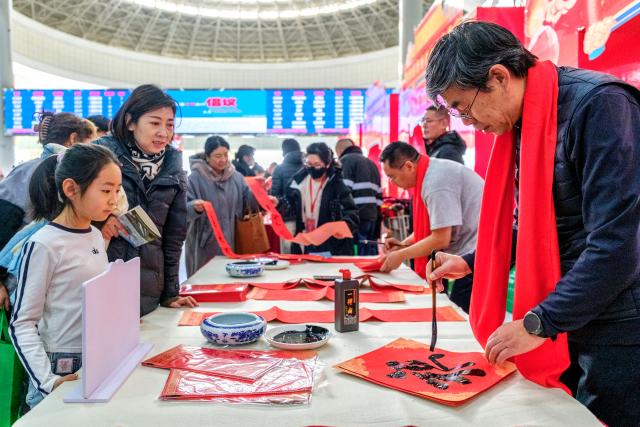 (260202) -- BEIJING, Feb. 2, 2026 (Xinhua) -- Calligraphers write Spring Festival couplets for passengers at Hohhot East Railway Station in Hohhot, north China's Inner Mongolia Autonomous Region, Feb. 2, 2026.
  China ushered in its largest annual population migration on Monday, 15 days ahead of the 2026 Spring Festival, also known as the Chinese New Year.
  A total of 9.5 billion passenger trips are expected during this year's travel rush period that will end on March 13, which will be a historic high. (Xinhua/Ma Jinrui)