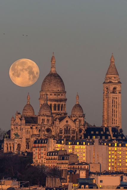 (260202) -- PARIS, Feb. 2, 2026 (Xinhua) -- A full snow moon is seen next to the Sacre Coeur Basilica at sunrise in Montmartre, Paris, France, Feb. 2, 2026. (Photo by Aurelien Morissard/Xinhua)