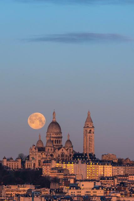 (260202) -- PARIS, Feb. 2, 2026 (Xinhua) -- A full snow moon is seen next to the Sacre Coeur Basilica at sunrise in Montmartre, Paris, France, Feb. 2, 2026. (Photo by Aurelien Morissard/Xinhua)