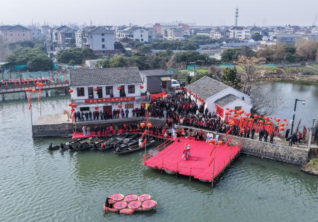 (260202) -- HANGZHOU, Feb. 2, 2026 (Xinhua) -- An aerial drone photo shows villagers watching a traditional water-town opera performance at Mojiaqiao Village in Hangzhou, east China's Zhejiang Province, Feb. 2, 2026. As the Chinese New Year approaches, Mojiaqiao Village in Hangzhou City has held a series of festive activities, recreating traditional Chinese New Year customs of a water town and creating a joyful atmosphere for the upcoming holiday. (Xinhua/Xu Yu)