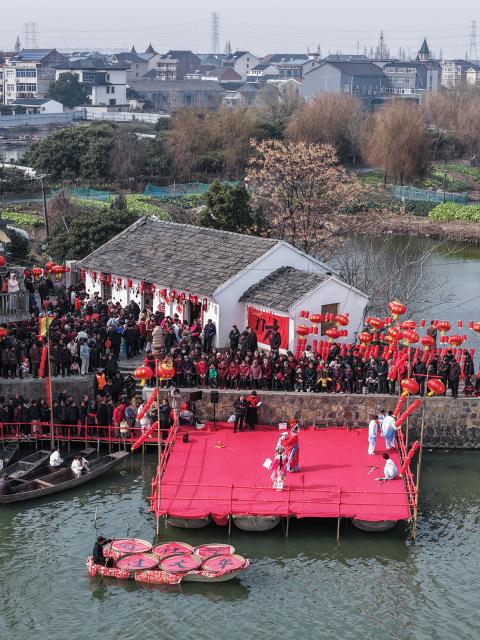 (260202) -- HANGZHOU, Feb. 2, 2026 (Xinhua) -- An aerial drone photo shows villagers watching a traditional water-town opera performance at Mojiaqiao Village in Hangzhou, east China's Zhejiang Province, Feb. 2, 2026. As the Chinese New Year approaches, Mojiaqiao Village in Hangzhou City has held a series of festive activities, recreating traditional Chinese New Year customs of a water town and creating a joyful atmosphere for the upcoming holiday. (Xinhua/Xu Yu)